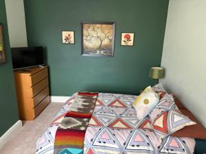 ein Schlafzimmer mit einem Bett mit einer farbenfrohen Bettdecke in der Unterkunft Murray Road in Rugby + 2 Fotos