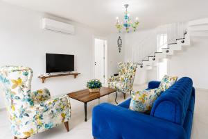 a living room with blue chairs and a tv at Villa Portakal Blossom in Dalyan