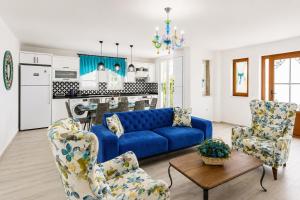 a living room with a blue couch and two chairs at Villa Portakal Blossom in Dalyan