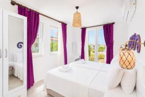 a white bedroom with purple curtains and a bed at Villa Portakal Blossom in Dalyan +24 photos