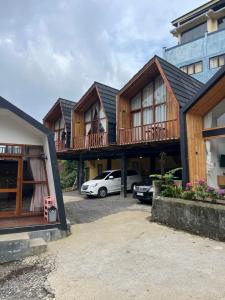 a row of houses with cars parked in a parking lot at Cabin Hillside Dieng in Diyeng