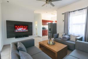 a living room with two couches and a tv at Trig Beacon in Manzini