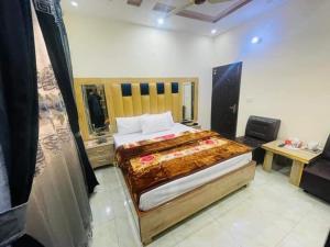 a bedroom with a large bed and a desk at Lasani view Guest House in Lahore
