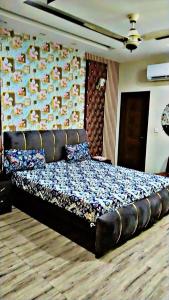 a large bed in a room with a wall at Lasani view Guest House in Lahore