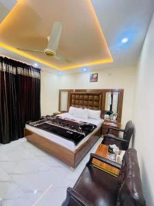 a bedroom with a large bed and a couch at Lasani view Guest House in Lahore