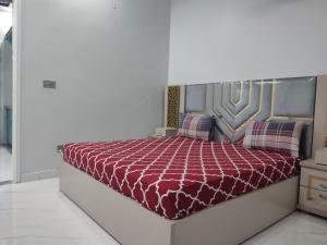 a bedroom with a bed with a red comforter at Lasani view Guest House in Lahore