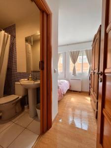 a bathroom with a sink toilet and a bed at HOSTAL MATILDAs in Segovia