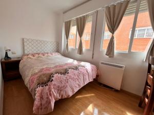 a bedroom with a bed and two windows at HOSTAL MATILDAs in Segovia