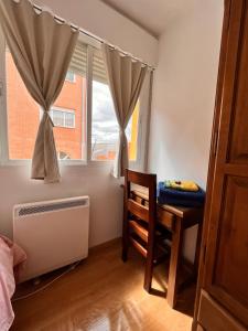 a bedroom with a desk and a window with a chair at HOSTAL MATILDAs in Segovia +27 photos