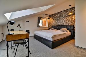 ein Schlafzimmer mit einem Bett und einem Schreibtisch in einem Zimmer in der Unterkunft Padre Boutique Hotel in Ostrava