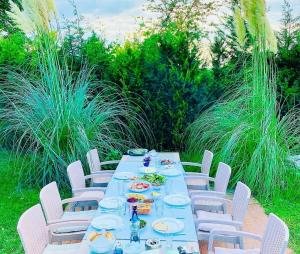 a long table with white chairs and plates of food at Göl Konuk Evi in Sakarya +17 photos