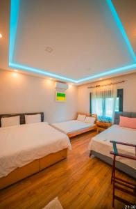 a bedroom with two beds and a blue light at Göl Konuk Evi in Sakarya