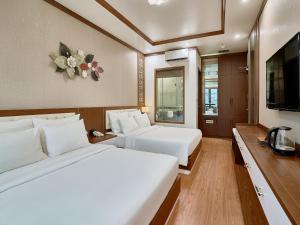 a hotel room with two beds and a television at NEW SUN NAM ĐỊNH hotel in Nam Ðịnh
