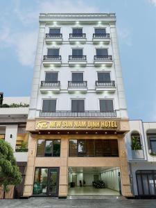 a tall white building with a new sun nan manghai hotel at NEW SUN NAM ĐỊNH hotel in Nam Ðịnh