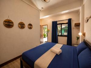 a bedroom with a blue bed with a towel on it at Island Lyfe Adventures Hotel - 5 Minutes from El Nido Airport & Lio Beach in El Nido