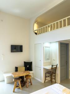 a room with a table and a bed and a desk at Villa Alisachni Andros in Agia Eleousa