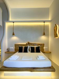 a bedroom with a large bed with two towels on it at Villa Alisachni Andros in Agia Eleousa