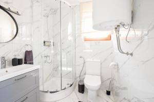 a white bathroom with a shower and a toilet at Golubek Holiday House in Banščica +24 photos