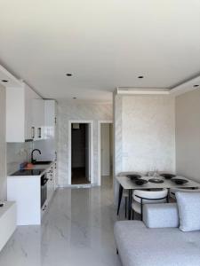 a kitchen and living room with a table and a couch at Bellanti2 in Igalo