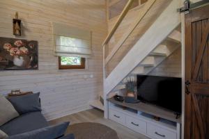 a living room with a tv and a staircase at Golubek Holiday House in Banščica