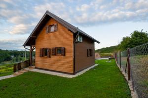 a small wooden house in a field of grass at Golubek Holiday House in Banščica