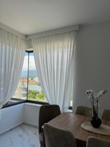 a dining room with a table and a large window at Morea Residence in Ulcinj