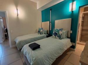 two beds in a room with blue walls at Stay at the Herold 605 in Herolds Bay +20 photos