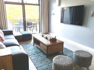 a living room with a couch and a tv at Stay at the Herold 605 in Herolds Bay