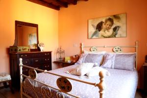 a bedroom with a bed with a dresser and a mirror at Guest House I Vicini di Cesare in Castelnuovo