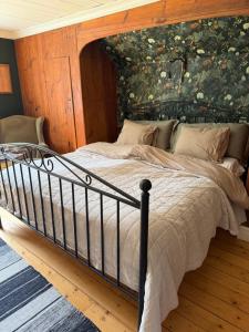 a bedroom with a large bed with a wooden wall at Flishult gård in Vetlanda