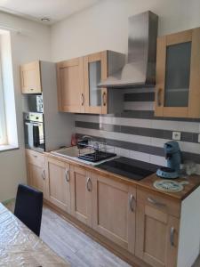 a kitchen with wooden cabinets and a stove top oven at Gîte Le 500 in Mayres