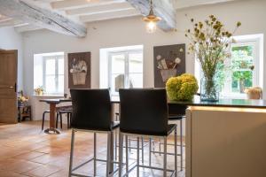 a kitchen with black chairs and a black counter at Moulin Dorceau - 15 couchages - voir notre site in Rémalard