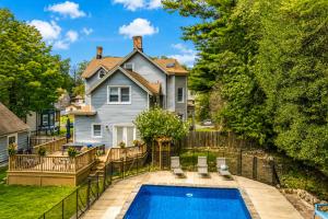 a home with a swimming pool in front of a house at Pool House Near NYC FIFA Stay for Groups in Roselle