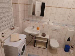 a white bathroom with a sink and a toilet at FeWo s Runde Wiese WR in Greifswald