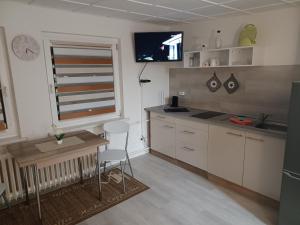 a kitchen with white cabinets and a table and a window at FeWo s Runde Wiese WR in Greifswald