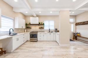 a kitchen with white cabinets and a tile floor at Pool House Near NYC FIFA Stay for Groups in Roselle