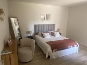 a bedroom with a bed and a chair at DOMITYS - Villa Molinis in Moulins +6 photos