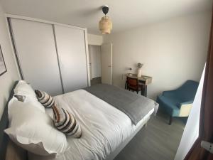 a bedroom with a white bed and a blue chair at DOMITYS - Villa Molinis in Moulins