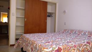 1 dormitorio con cama y armario de madera en Hermoso Departamento Céntrico en Villa Carlos Paz