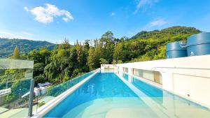 a swimming pool on top of a building with trees at Peaceful Fantasia Condo Kamala in Surin Beach