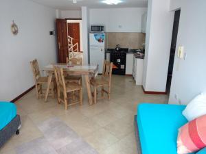 cocina y comedor con mesa y sillas en Hermoso Departamento Céntrico en Villa Carlos Paz