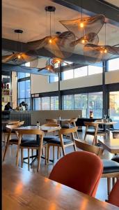 a restaurant with wooden tables and chairs and windows at Midrand Stylish 1Bedroom Escape in Midrand