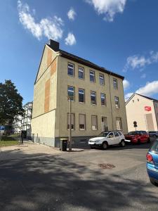 a building with cars parked in a parking lot at Stilvolles Apartment Eigenständiger Check-in in Dessau