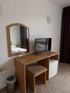 a desk with a television and a mirror in a room at Hotel Jasmine in Byala