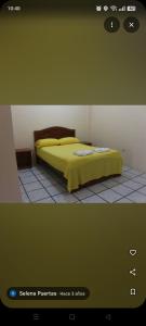 a bedroom with a bed with a yellow blanket at Hostal El Bosque in Pedernales