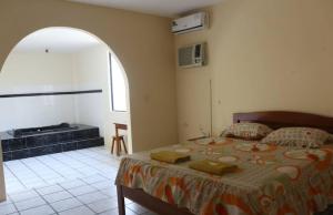 a bedroom with a bed in a room with a window at Hostal El Bosque in Pedernales