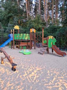 a playground with different types of play equipment in the sand at Domki Wakacyjne nad Jeziorem in Janowice