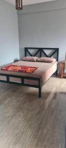 a bed in a room with a wooden floor at Ramboda Rest in Nuwara Eliya