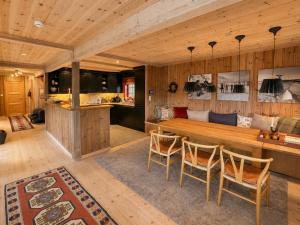 a kitchen and dining room with a wooden table and chairs at Spacious cabin with beautiful Geilo views in Geilo