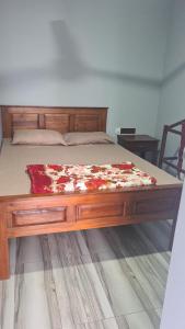 a bed in a bedroom with a wooden bed frame at Ramboda Rest in Nuwara Eliya